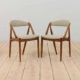 a pair of teak chairs