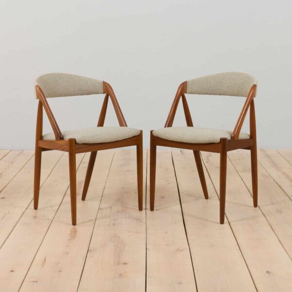 a pair of teak chairs