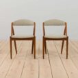a pair of teak chairs