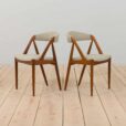 a pair of teak chairs