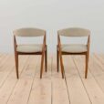 a pair of teak chairs